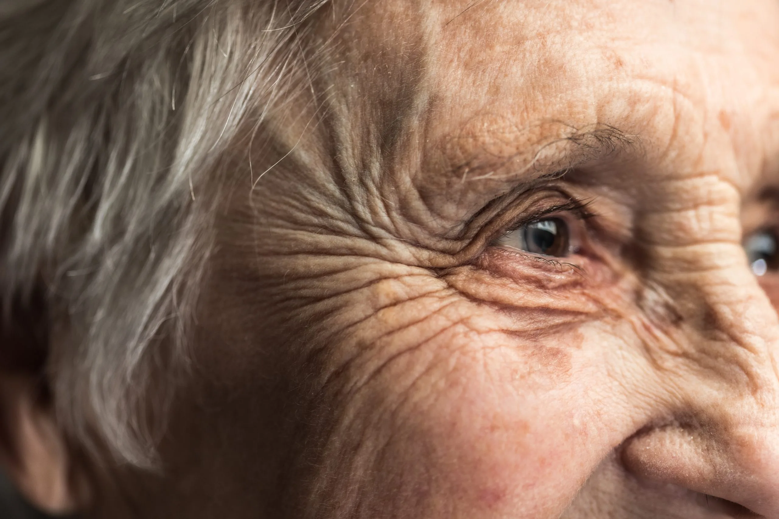Close up portrait of the side of an elderly woman's face, capturing the eyes