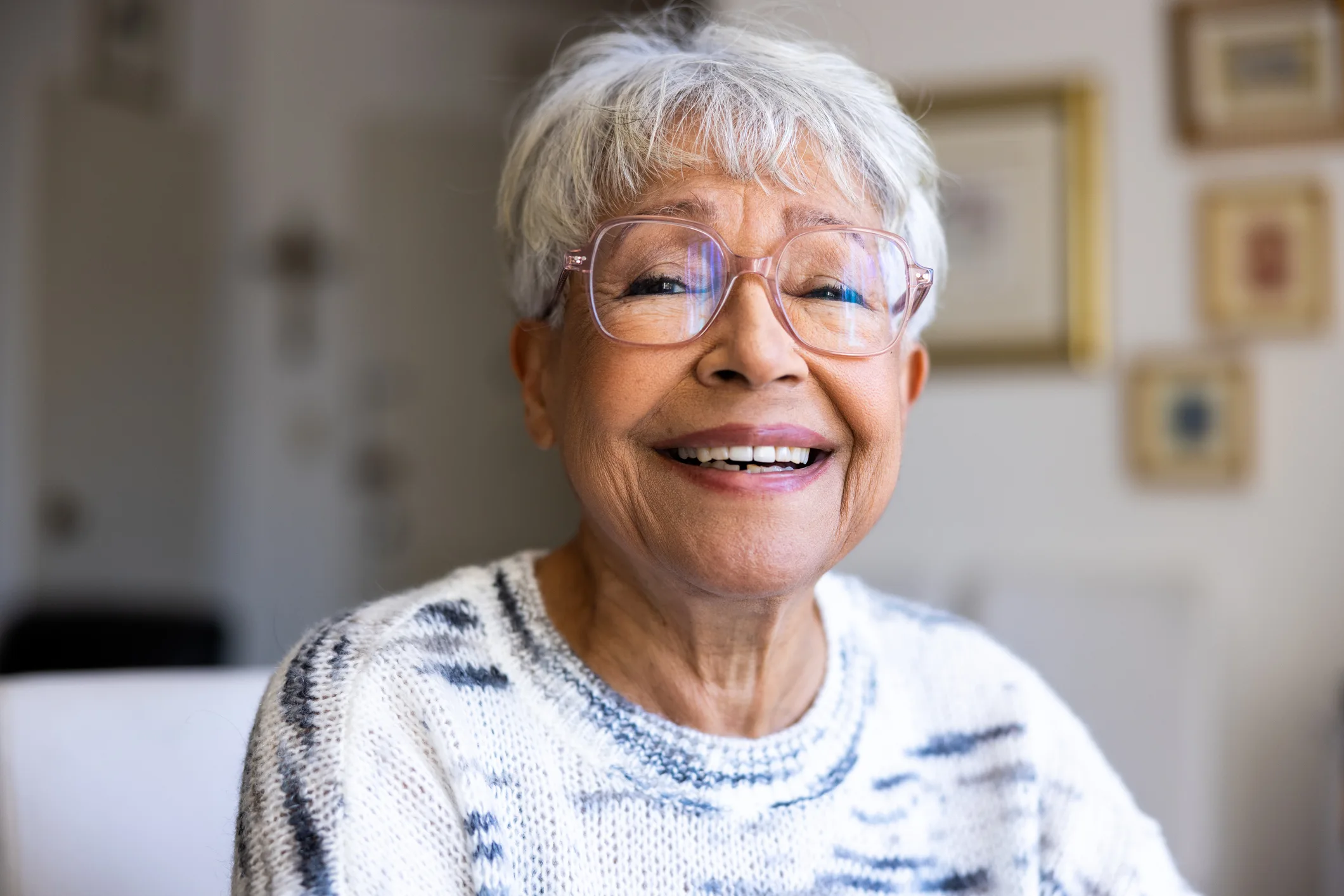 Portrait of a beautiful senior woman smiling at the camera in her home